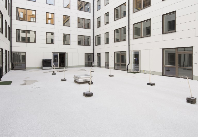 Innergård med genomfärgad och slipad gjutasfalt